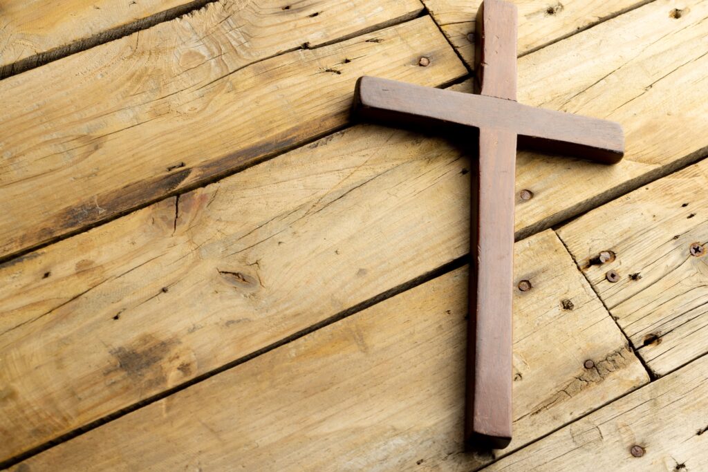 Image of close up of cross and copy space on wooden background. Easter, religion, tradition and celebration concept.